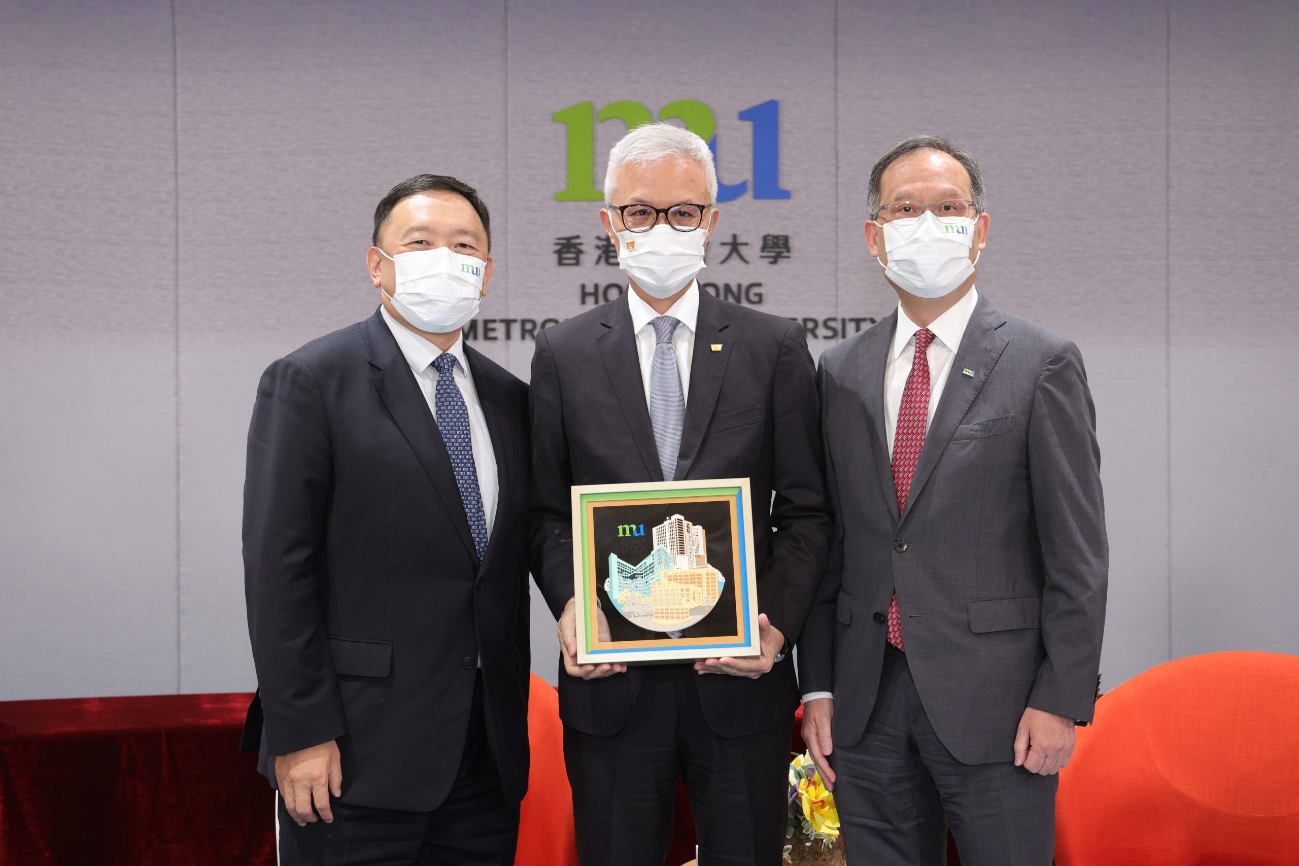 香港都会大学校董会主席黄天祥博士工程师（左）及校长林群声教授（右）致送纪念品予香港故宫文化博物馆馆长吴志华博士（中）。