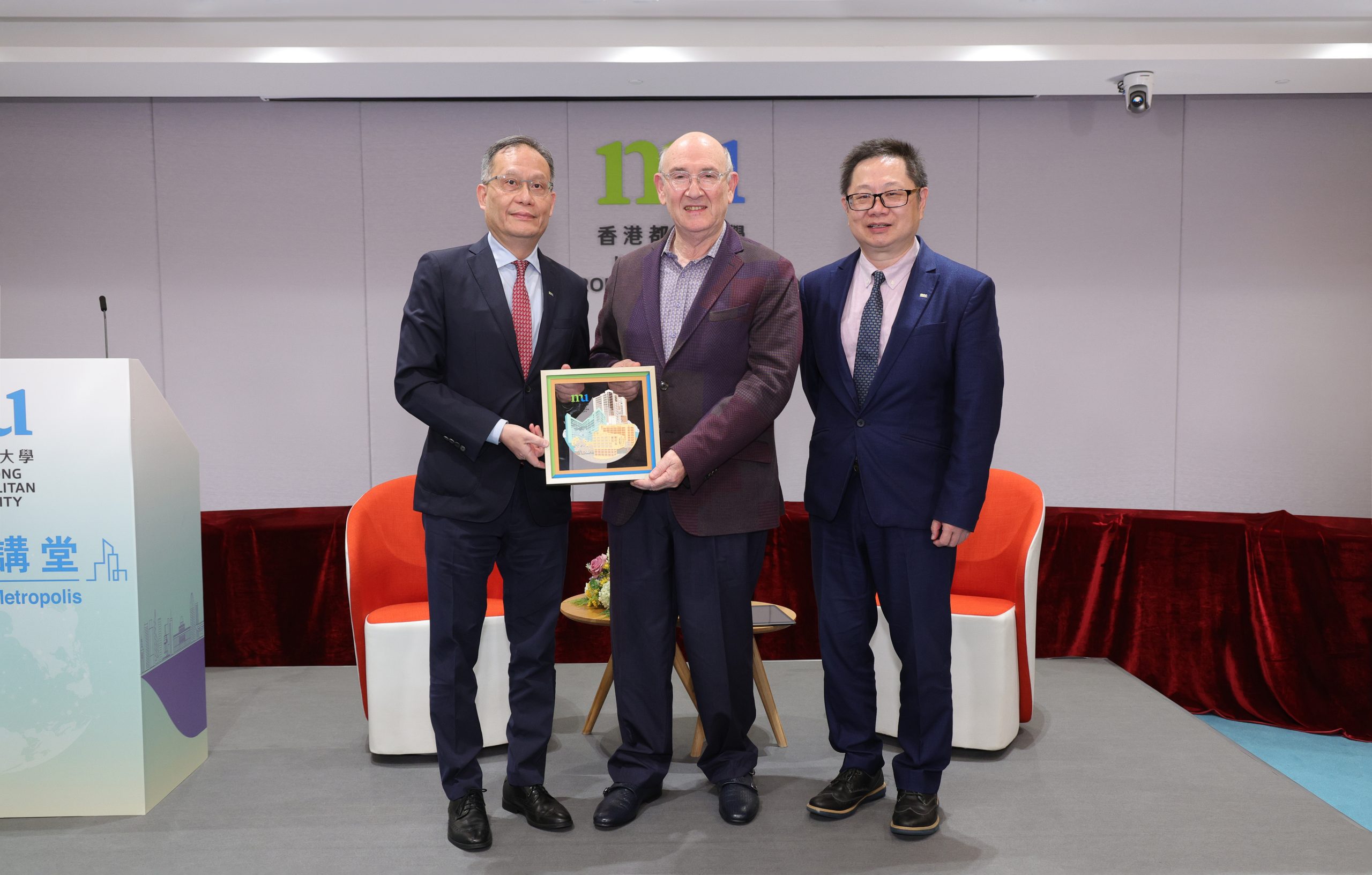 HKMU President Prof. Paul Lam Kwan-sing (left) and Provost Prof. Reggie Kwan Ching-ping (right) present a souvenir to HKBU Chair Professor Prof. Jeffrey Shaw (middle).